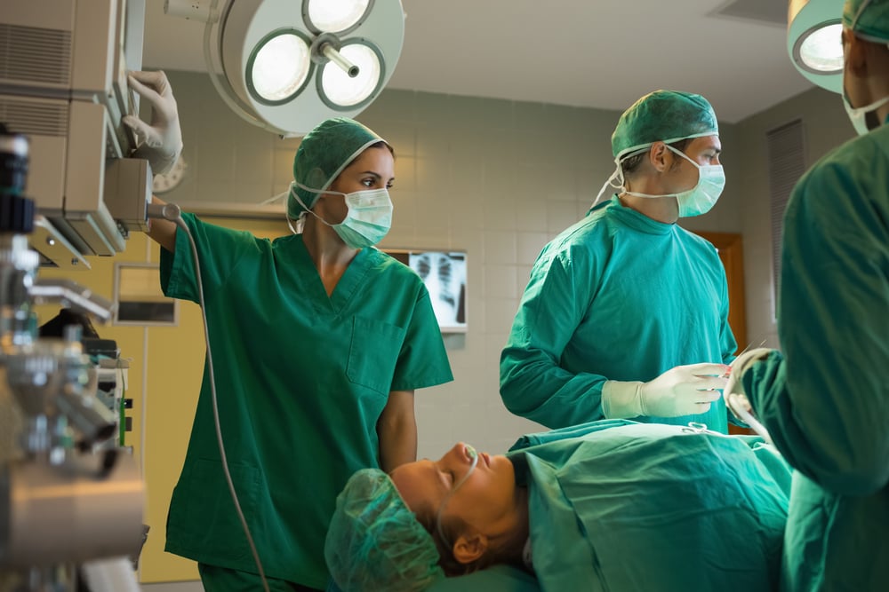 Surgeons working on a female patient in an operating theater